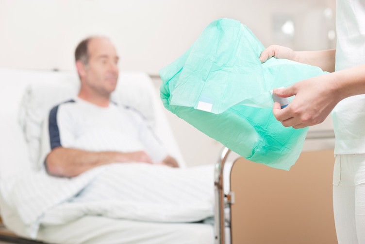 Ein Patient wird mit einer Inkontinenzvorlage versorgt