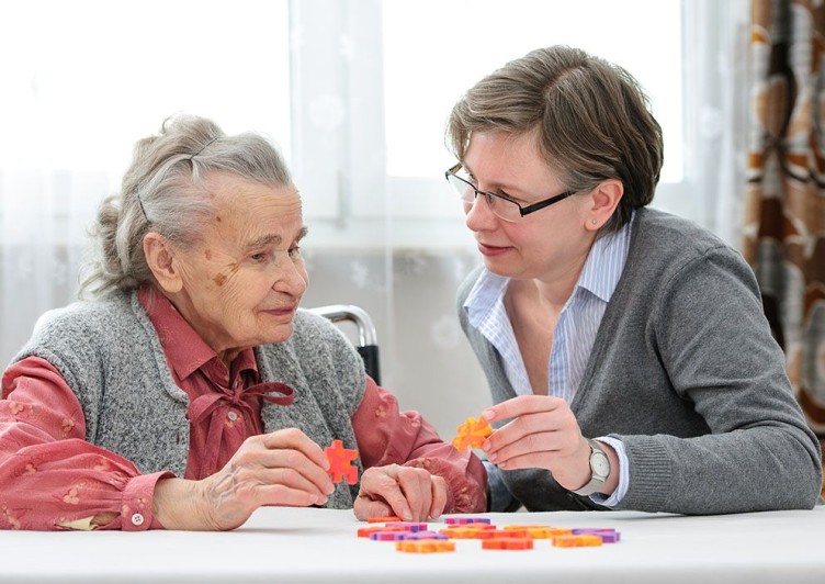 Eine ältere und eine jüngere Frau sitzen an einem Tisch in einer Alten-WG