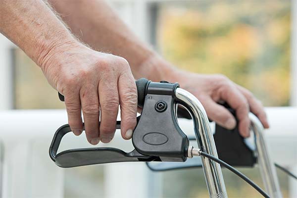Die Hände eines älteren Menschen an einem Rollator