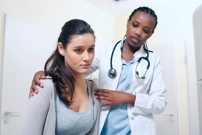 Eine Ärztin tröstet eine Patientin,