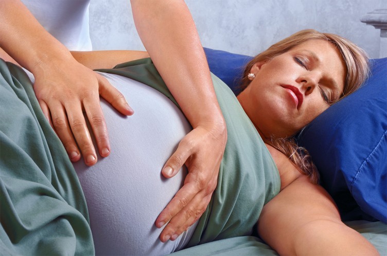 Eine Hebamme betreut eine schwangere Frau