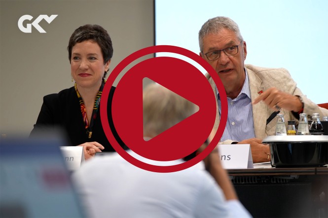 Die Vorsitzenden des Verwaltungsratrs, Dr. Susanne Wagenmann und Uwe Klemens, während der Sitzung des Verwaltungsrates. Davor ist ein roter Play-Button zu sehen.