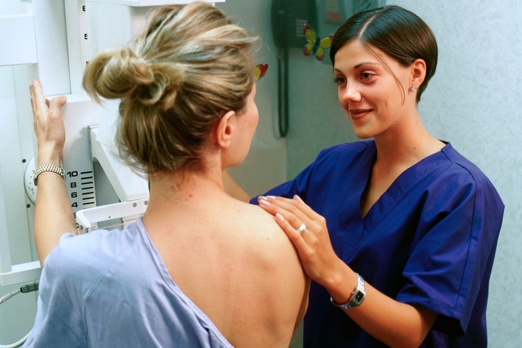 Eine Patientin und eine Röntgenassistentin bei der Mammographie