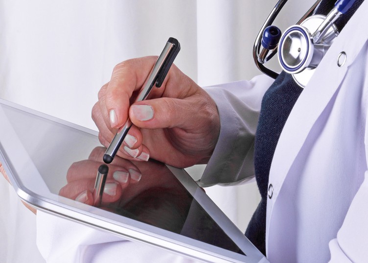 Eine Ärztin schreibt etwas auf einem Tablet