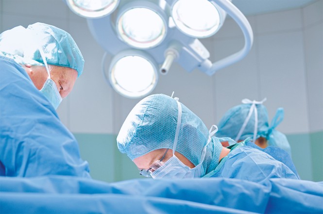 Drei Ärzte und Pflegekräfte während einer Operation in einem Krankenhaus