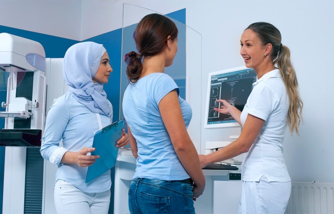 Eine Patientin und zwei MTA vor der Mamografie 