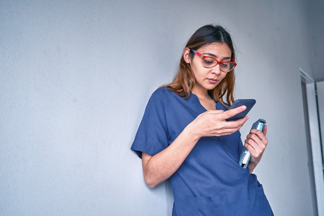 Eine Pflegekraft benutzt ein Smartphone