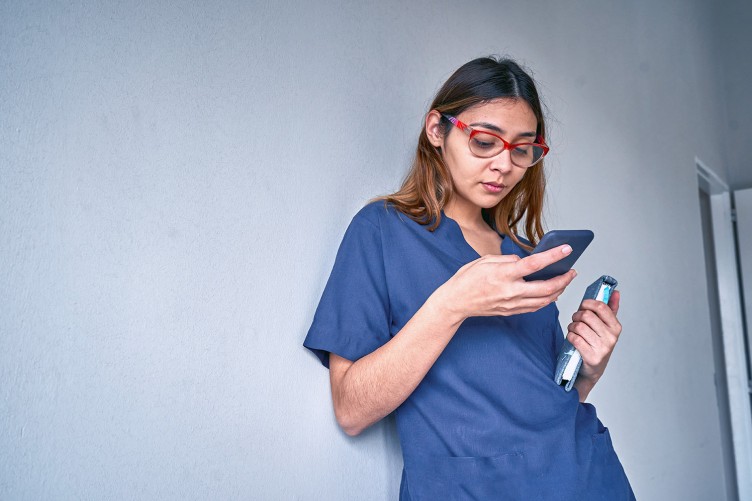 Eine Pflegekraft benutzt ein Smartphone