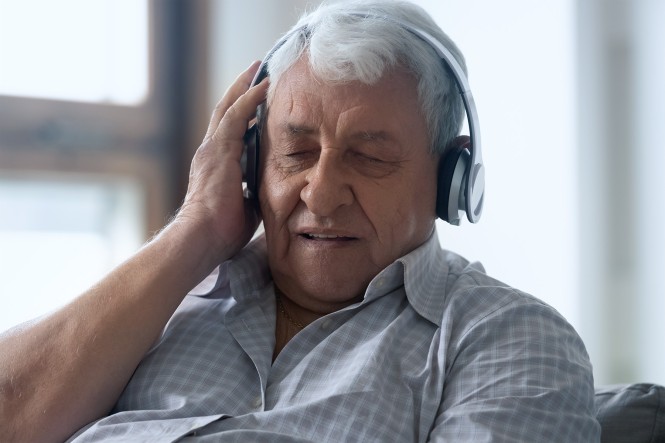 Ein älterer Mann hört Musik über Kopfhörer