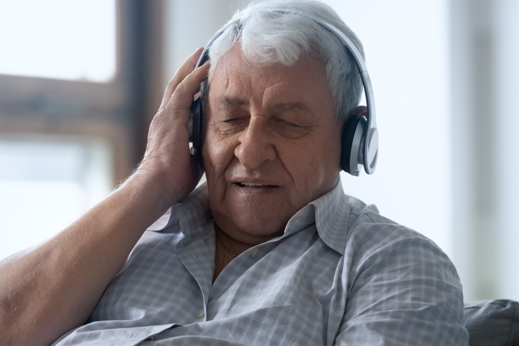 Ein älterer Mann hört Musik über Kopfhörer